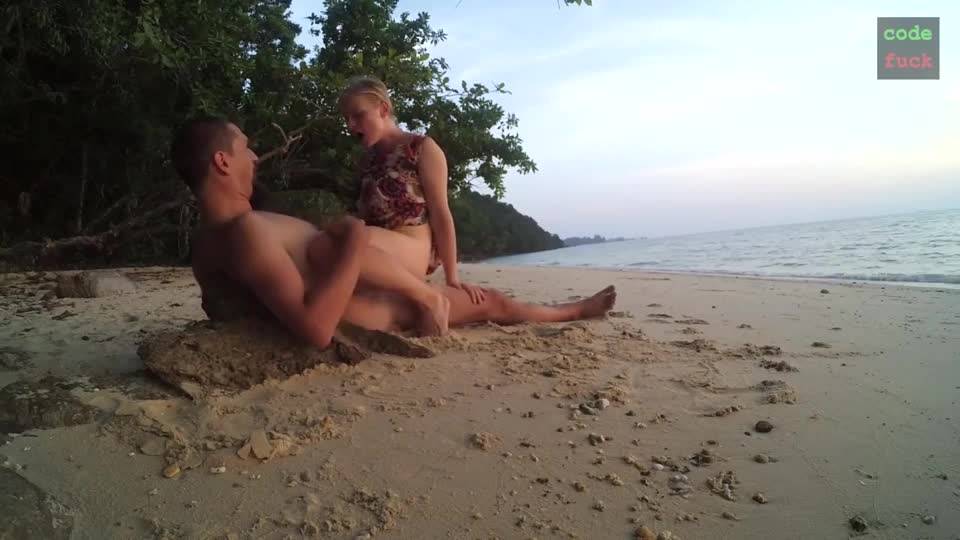 Plan cul sur la plage avec une jeune blonde