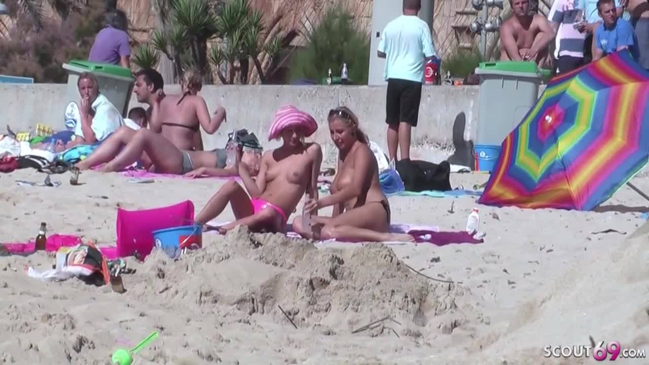 Couple de jeunes lesbiennes topless à la plage